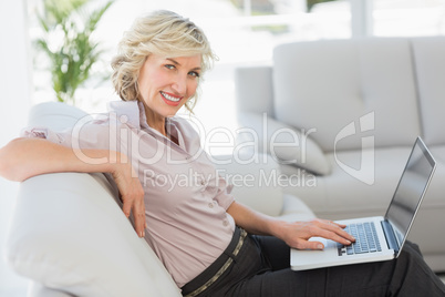 Beautiful businesswoman using laptop in living room