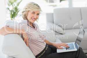 Beautiful businesswoman using laptop in living room