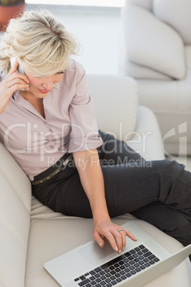 Businesswoman using laptop in living room