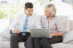Smart businessman and his secretary with diary and laptop