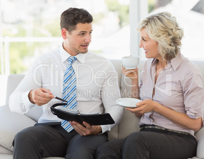 Businessman and his secretary  with diary and tea cup