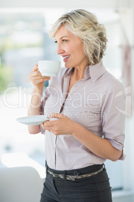 Smiling beautiful businesswoman drinking tea in office Smiling beautiful businesswoman drinking tea in office