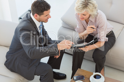Businessman and his secretary  looking at diary at home