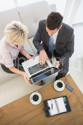 Businessman and his secretary with laptop and diary at home