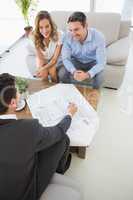 Smiling couple in meeting with a financial adviser