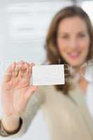Smiling businesswoman holding blank card
