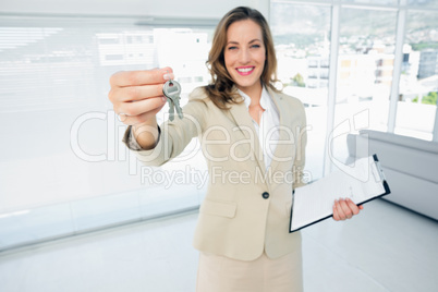 Beautiful happy woman handing over house keys