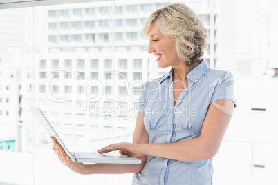 Happy businesswoman using laptop