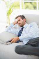 Relaxed well dressed man watching tv in living room