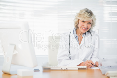 Smiling female doctor with computer at medical office