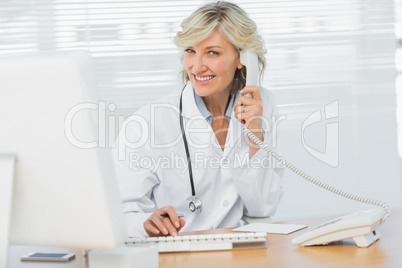 Female doctor with computer using phone at medical office Female doctor with computer using phone at medical office