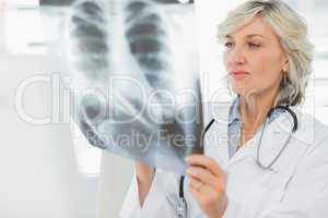 Serious female doctor examining x-ray