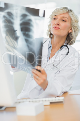 Serious female doctor examining x-ray