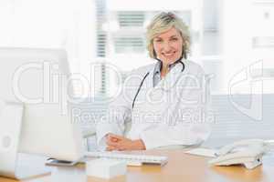 Female doctor sitting with computer at medical office