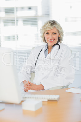 Female doctor sitting with computer at medical office