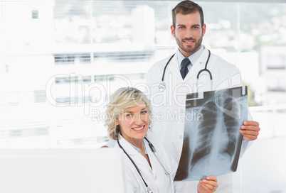 Female and male doctors with x-ray at medical office