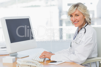 Female doctor using computer at desk in medical office