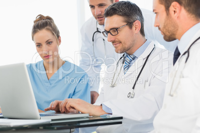 Group of concentrated doctors using laptop