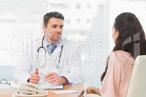 Doctor listening to patient with concentration at desk