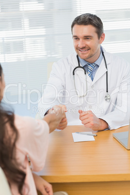 Doctor and patient shaking hands in medical office