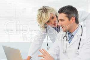 Two concentrated doctors using laptop together