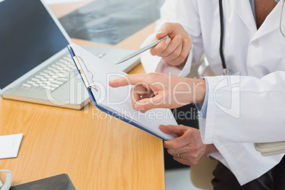 Close-up mid section of two doctors in meeting
