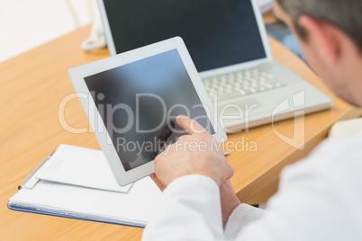 Doctors using laptop and digital tablet in meeting