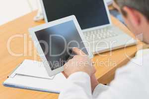 Doctors using laptop and digital tablet in meeting