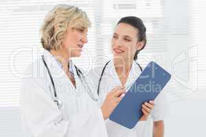 Two female doctors reading medical reports