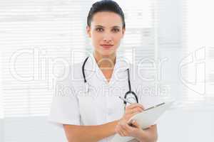 Beautiful young female doctor with clipboard