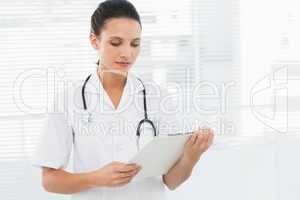 Beautiful young female doctor with clipboard