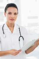 Beautiful young female doctor with clipboard