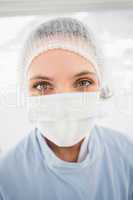 Female surgeon wearing surgical cap and mask