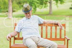 Relaxed senior man on bench at park