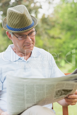 Senior man reading newspaper at park