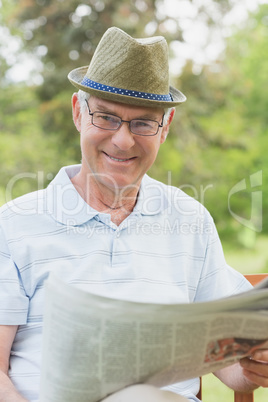 Senior man reading newspaper at park