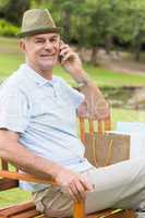 Relaxed senior man using mobile phone at park
