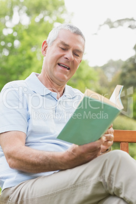 Senior man reading a book at park