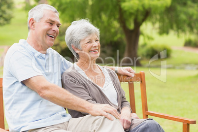 Side view of senior couple sitting on bench at park