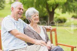 Side view of senior couple sitting on bench at park