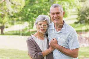 Loving happy senior couple holding hands at park