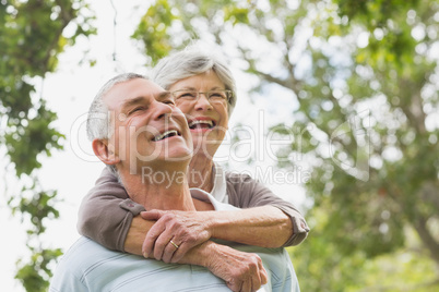 Senior woman embracing man from behind