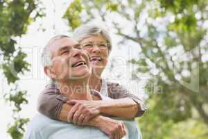 Senior woman embracing man from behind