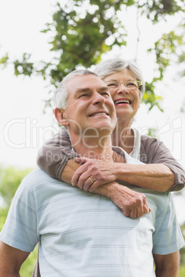 Senior woman embracing man from behind