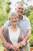 Senior man embracing woman from behind at the park