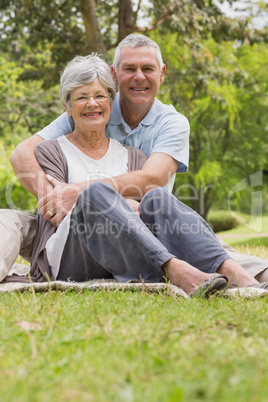 Senior man embracing woman from behind at park