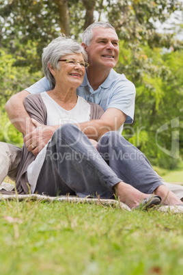 Senior man embracing woman from behind at park