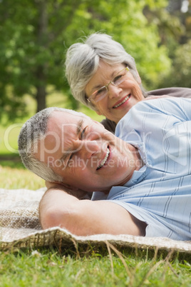 Close-up portrait of a senior couple lying at park