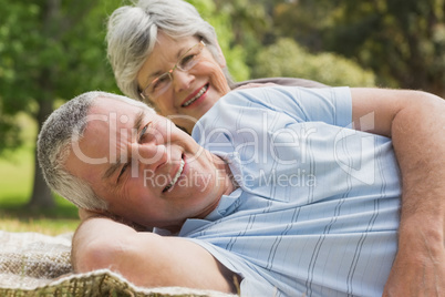 Close-up portrait of a senior couple lying at park