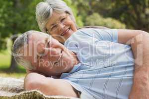 Close-up portrait of a senior couple lying at park